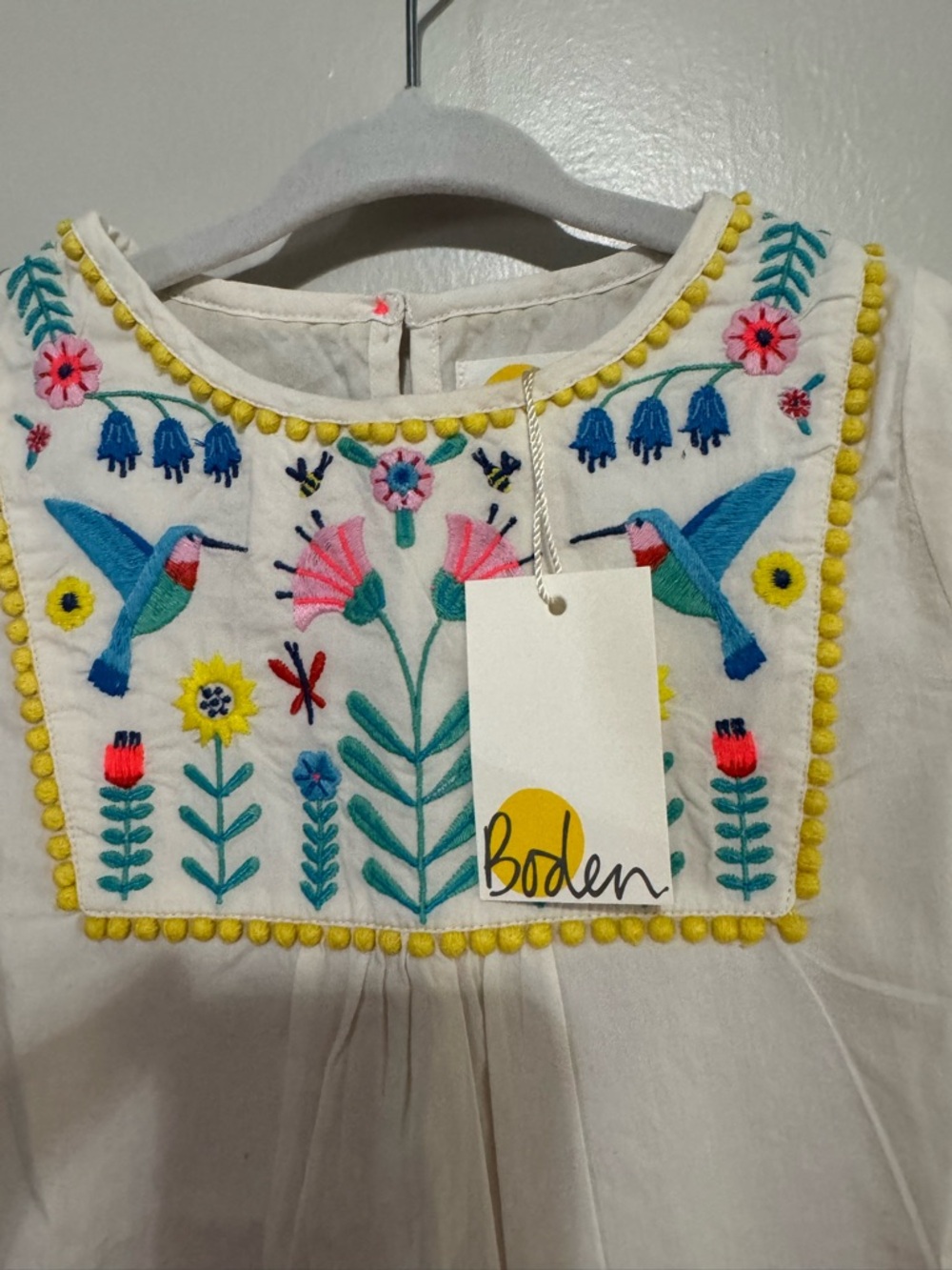 Mini Boden NWT- Cream Embroidered Floral Bib Top with Yellow Pom Trim